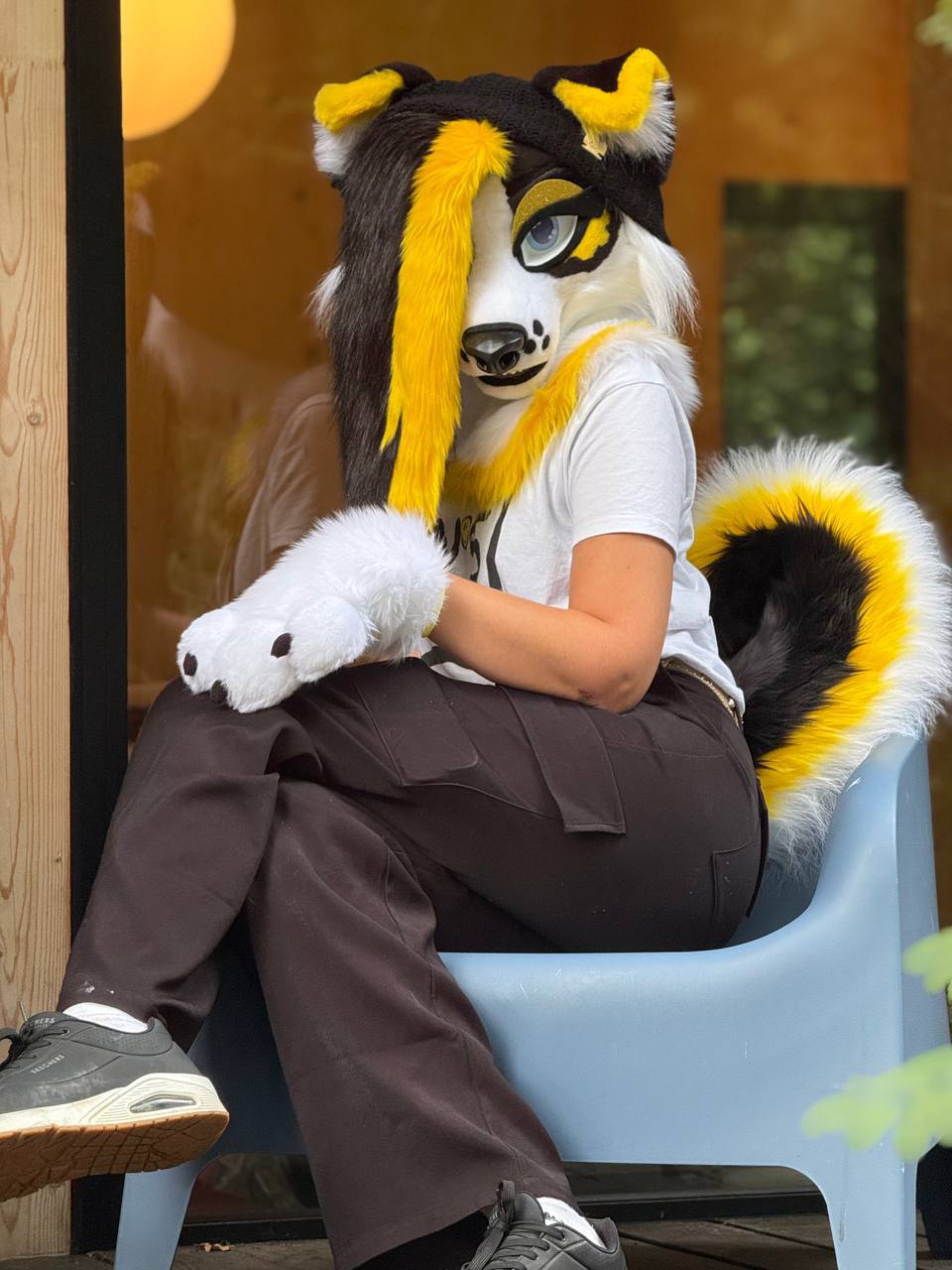Person puppy costume sitting on a chair.