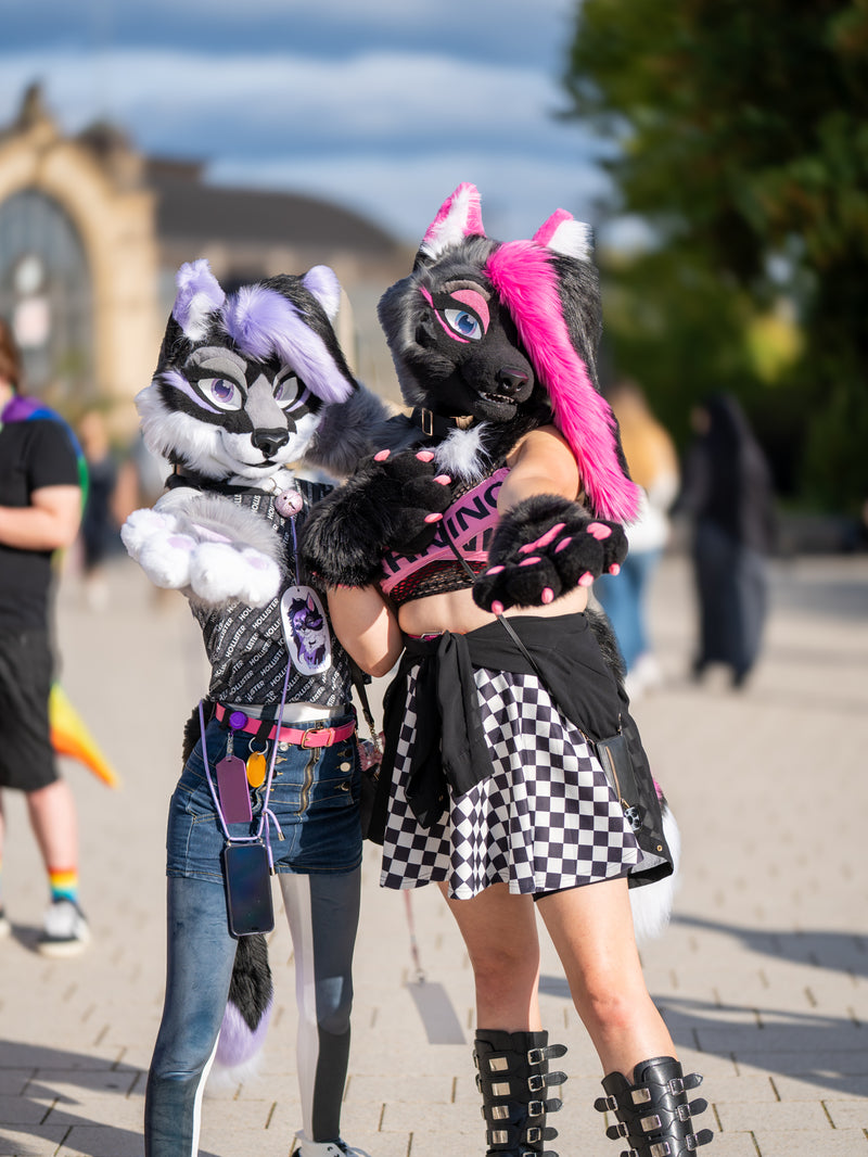 Two people in animal-themed costumes standing outdoors on a sunny day.