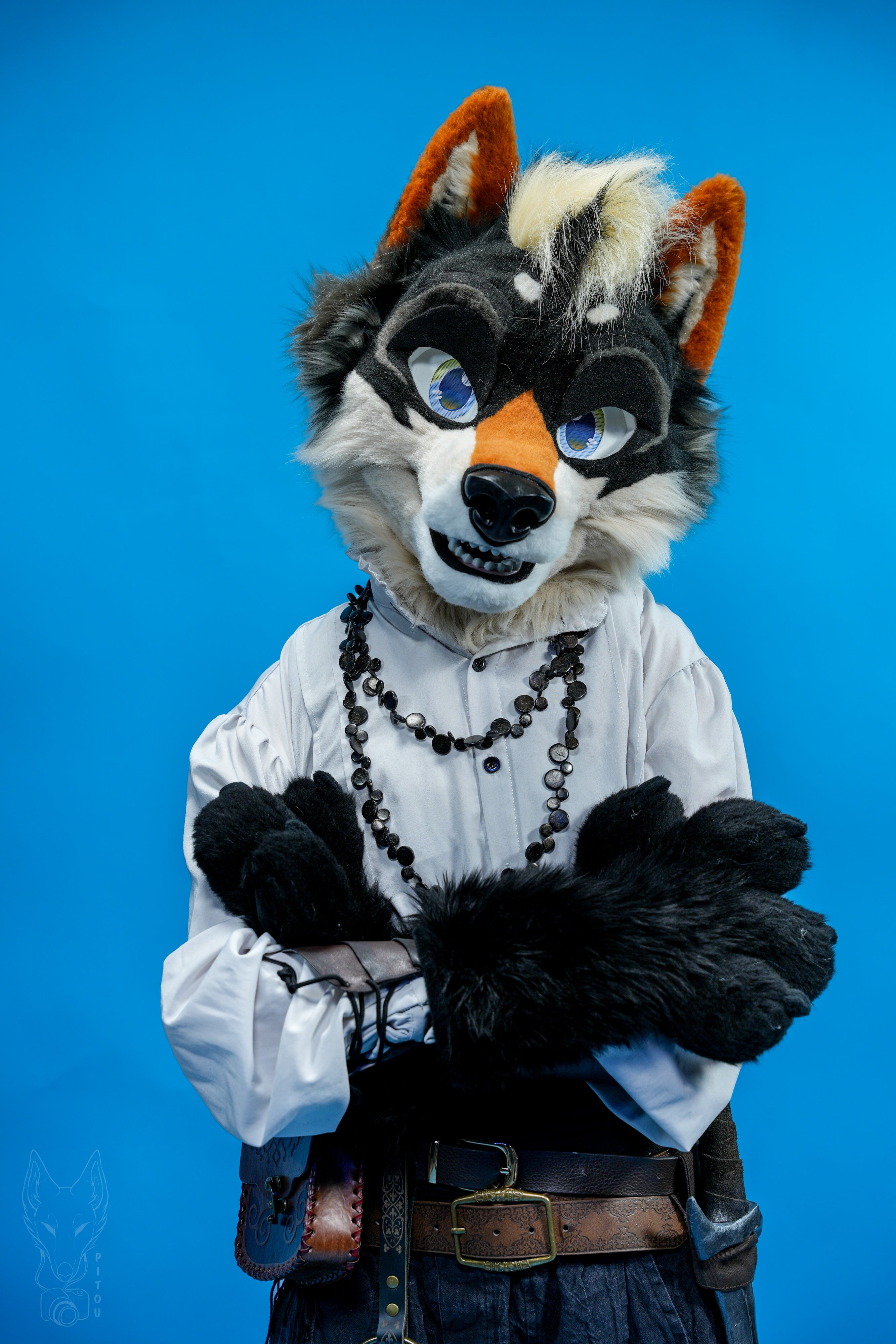 Person wearing a detailed animal mask and costume against a blue background