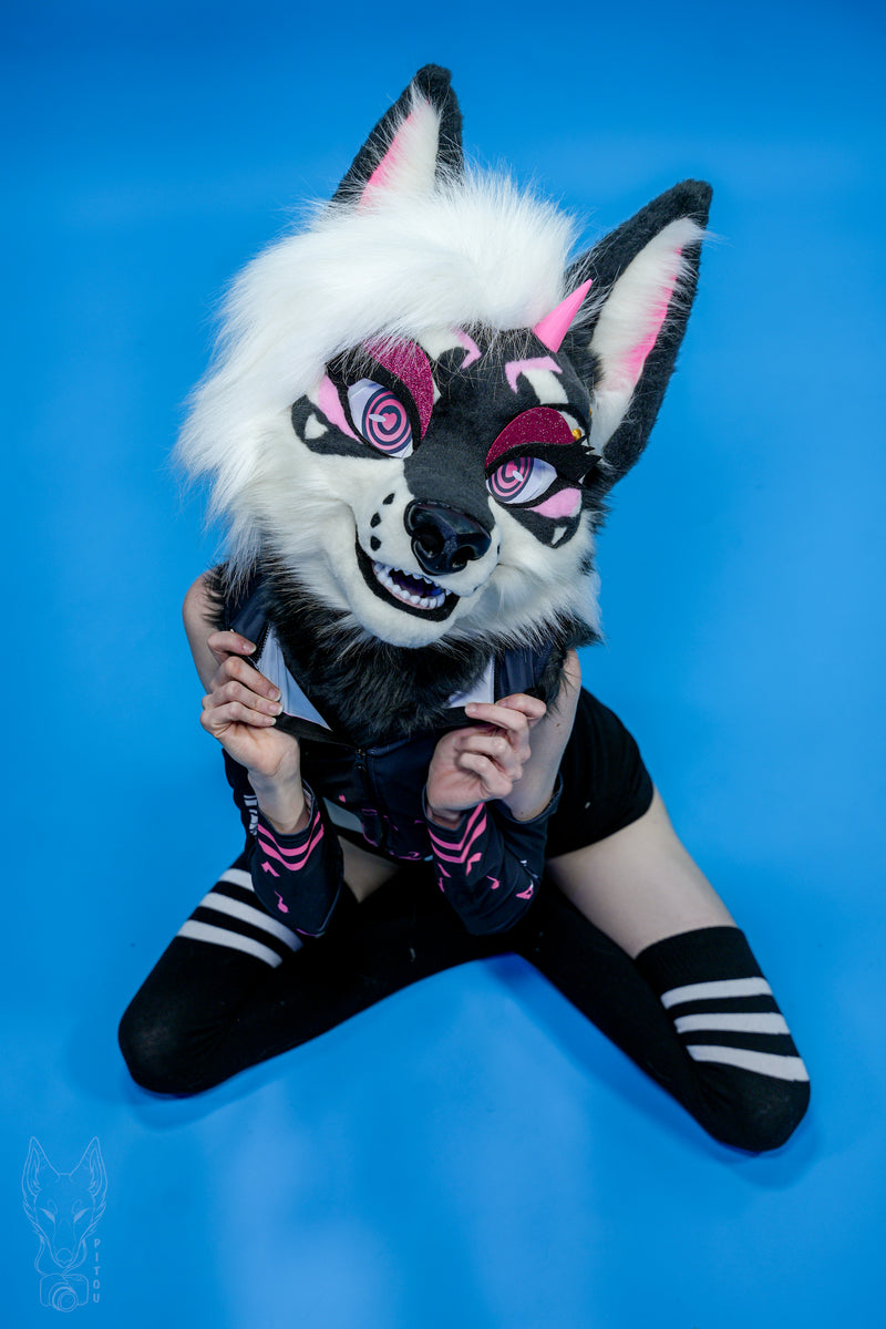 Person wearing a detailed animal mask on a blue background